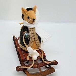 Felt squirrel riding a sled